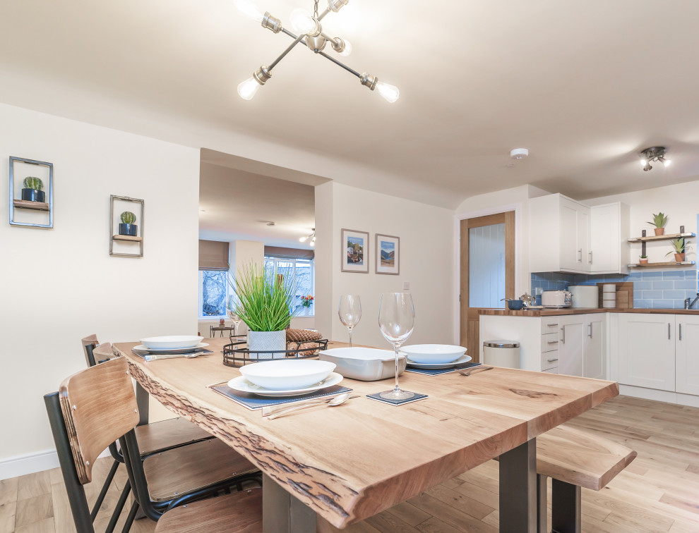 Photo of a mid-sized industrial u-shaped eat-in kitchen in Other with a single-bowl sink, shaker cabinets, beige cabinets, laminate benchtops, blue splashback, ceramic splashback, panelled appliances, medium hardwood floors, no island and brown benchtop.