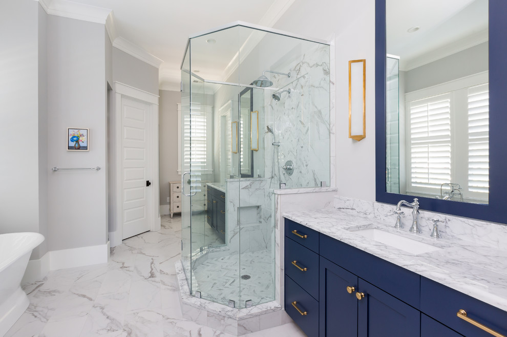 Inspiration for a mid-sized beach style master bathroom in Charleston with furniture-like cabinets, blue cabinets, a freestanding tub, an alcove shower, a two-piece toilet, white tile, marble, grey walls, marble floors, a vessel sink, marble benchtops, white floor, a hinged shower door and white benchtops.