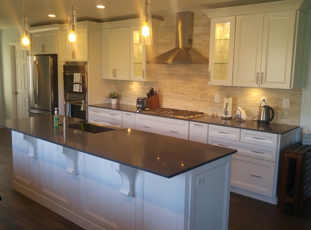 Mid-sized transitional galley eat-in kitchen in Salt Lake City with a farmhouse sink, recessed-panel cabinets, white cabinets, quartz benchtops, beige splashback, limestone splashback, stainless steel appliances, vinyl floors, with island and grey floor.