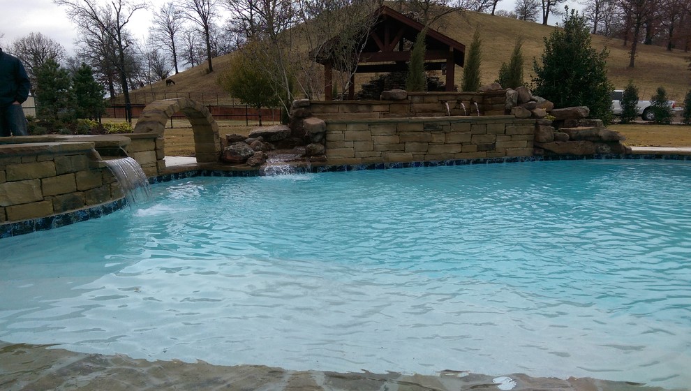 Pool fountain - rustic backyard stone and kidney-shaped lap pool fountain idea