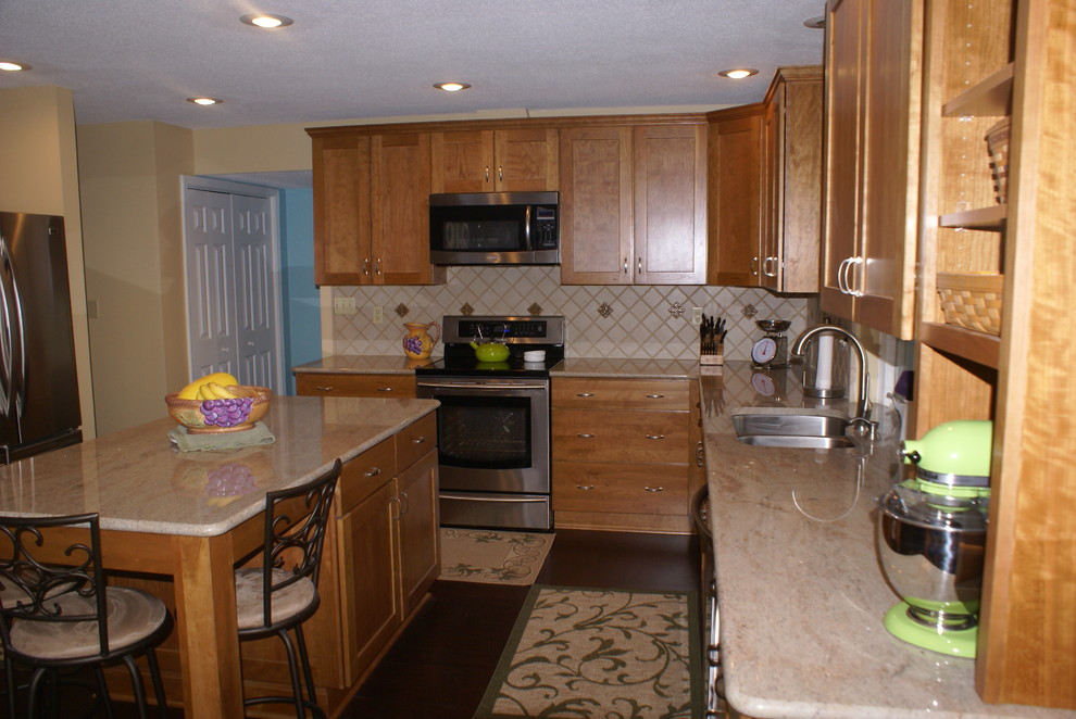 Example of a transitional l-shaped eat-in kitchen design in Indianapolis with an undermount sink, recessed-panel cabinets, light wood cabinets, granite countertops and stainless steel appliances