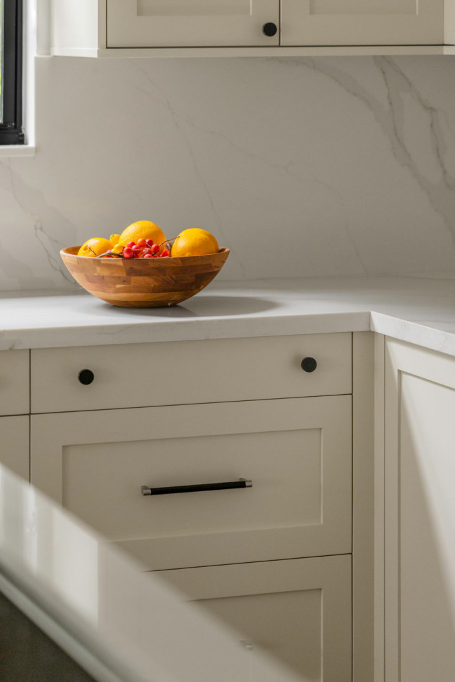 Eat-in kitchen - mid-sized transitional l-shaped laminate floor and brown floor eat-in kitchen idea in Miami with a drop-in sink, shaker cabinets, medium tone wood cabinets, quartz countertops, white backsplash, quartz backsplash, stainless steel appliances, an island and white countertops