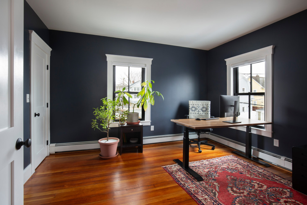 Mittelgroßes Klassisches Arbeitszimmer mit Arbeitsplatz, blauer Wandfarbe, braunem Holzboden und freistehendem Schreibtisch in Boston
