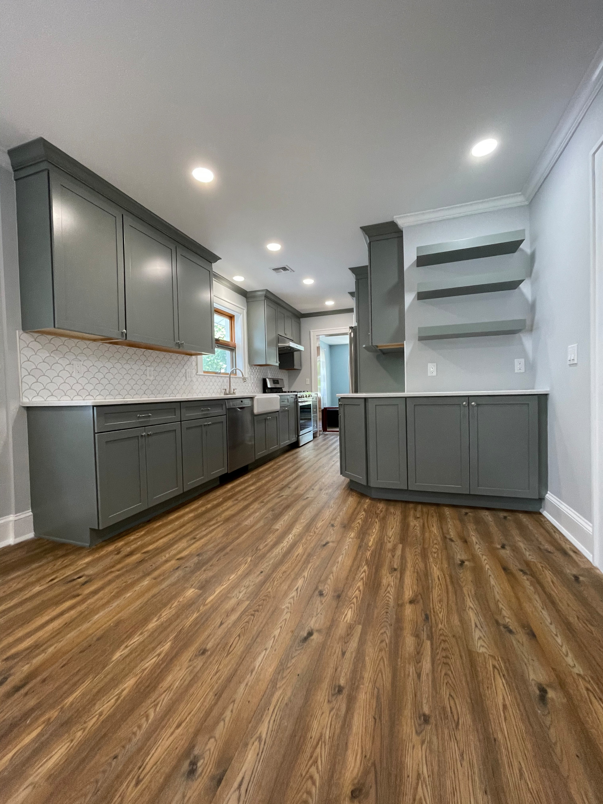 This kitchen has a fresh and casual feeling . Grey cabinets adds unique flare
