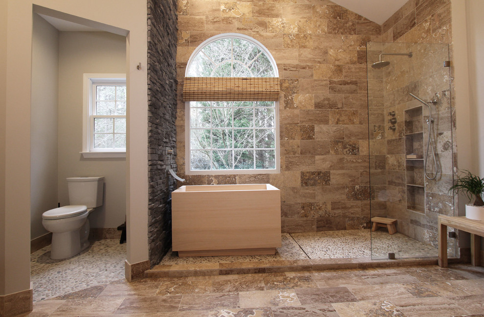 Photo of a large asian master bathroom in Atlanta with flat-panel cabinets, a japanese tub, an open shower, a two-piece toilet, brown tile, grey walls, travertine floors, a vessel sink and travertine.