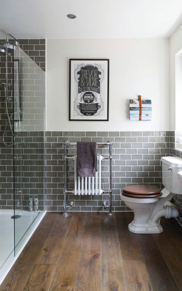 Foto de cuarto de baño clásico con ducha a ras de suelo, sanitario de dos piezas, baldosas y/o azulejos grises, paredes blancas, suelo de madera oscura, suelo marrón y ducha abierta
