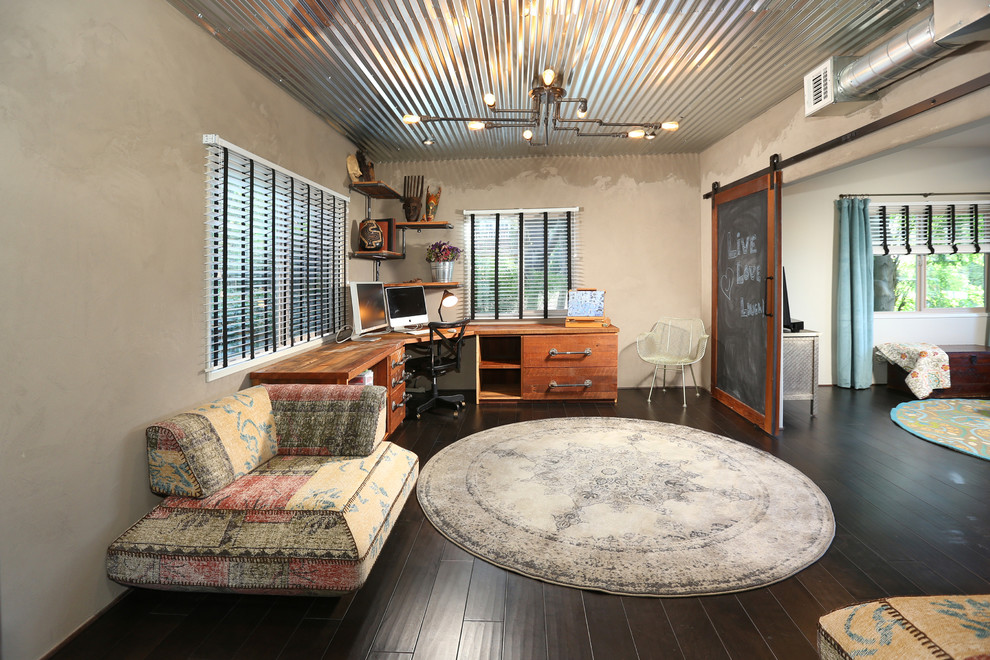 Example of a large urban freestanding desk dark wood floor and brown floor study room design in Los Angeles with gray walls