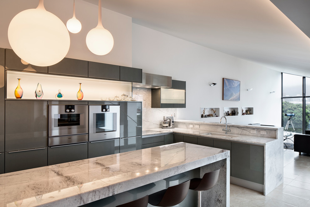 Design ideas for a modern l-shaped eat-in kitchen in Wellington with an undermount sink, flat-panel cabinets, grey cabinets, quartzite benchtops, white splashback, stainless steel appliances, ceramic floors and with island.