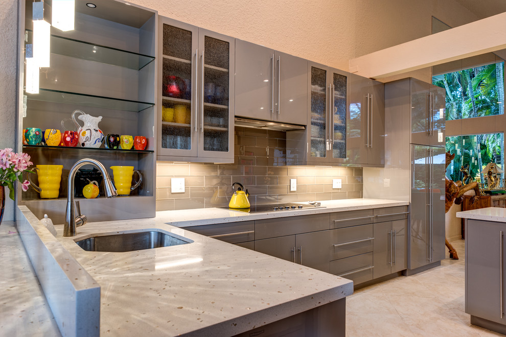 This is an example of a large eclectic l-shaped open plan kitchen in Columbus with an undermount sink, flat-panel cabinets, grey cabinets, quartzite benchtops, grey splashback, glass sheet splashback, panelled appliances, ceramic floors, with island and beige floor.