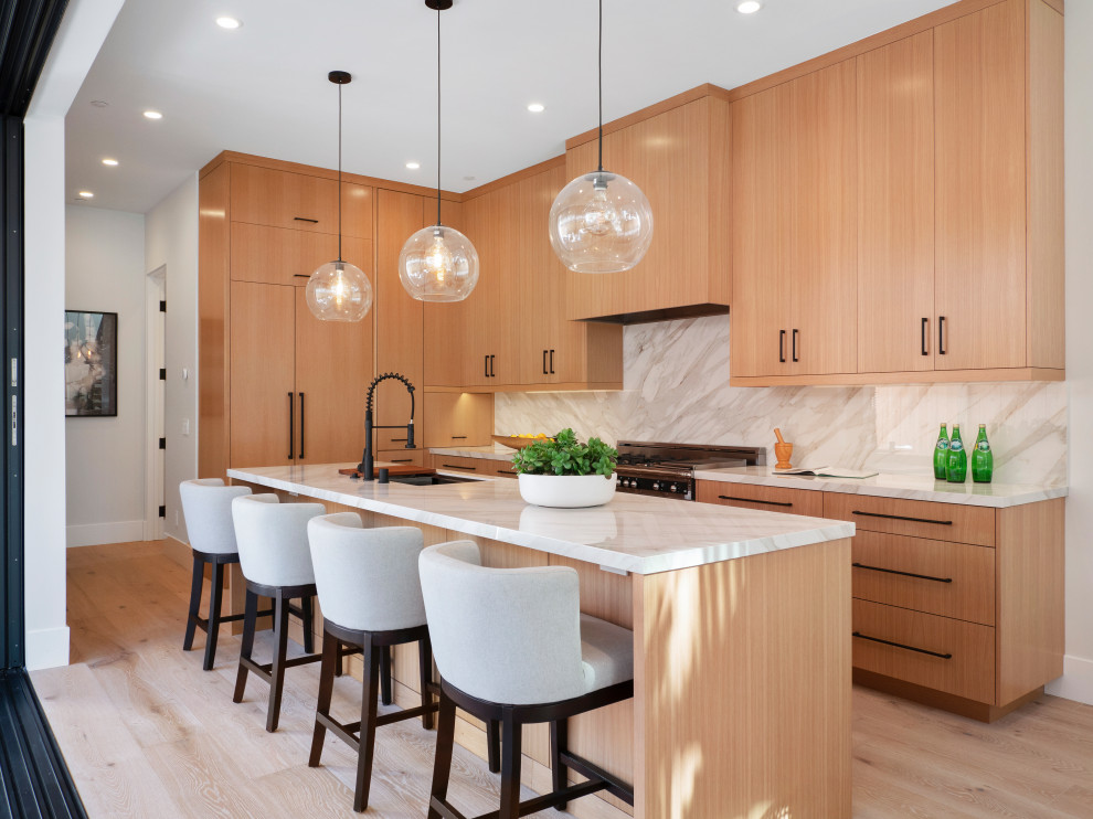 Design ideas for a contemporary l-shaped kitchen in Orange County with an undermount sink, flat-panel cabinets, medium wood cabinets, white splashback, stainless steel appliances, light hardwood floors, with island, beige floor and white benchtop.
