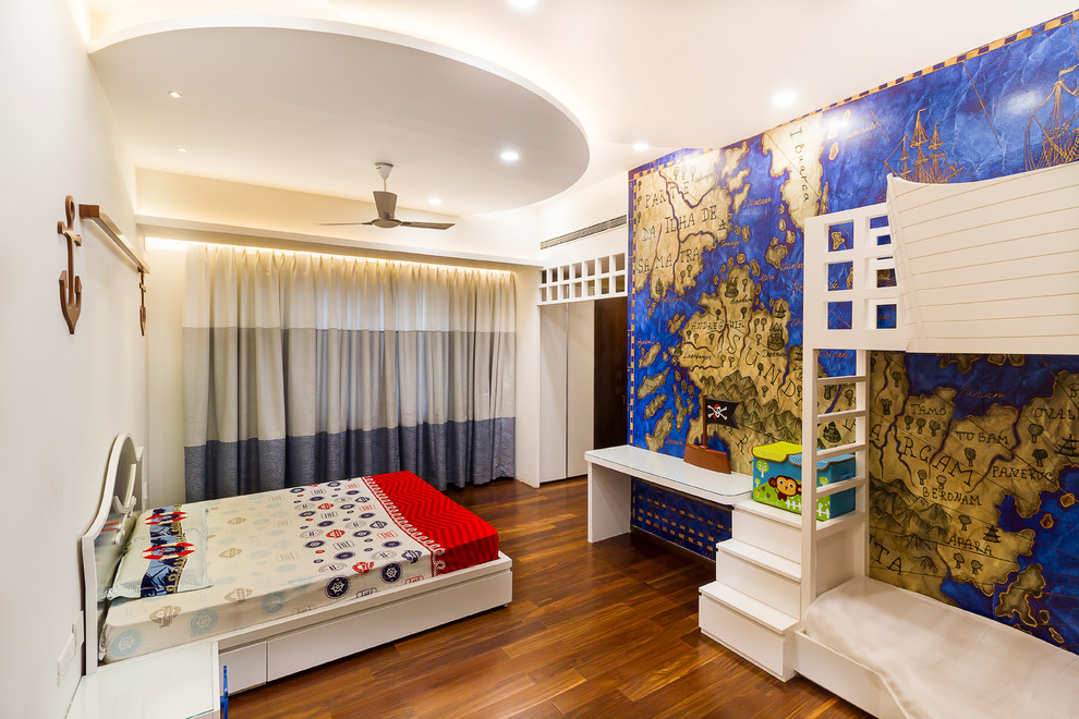 Photo of a contemporary kids' bedroom for kids 4-10 years old and boys in Bengaluru with multi-coloured walls, medium hardwood floors and brown floor.
