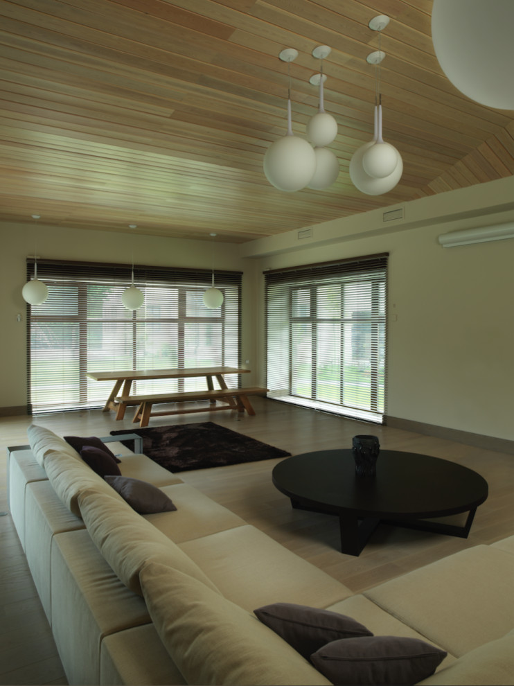 Exempel på ett stort modernt vardagsrum, med beige väggar, ljust trägolv, en standard öppen spis, en spiselkrans i sten och beiget golv