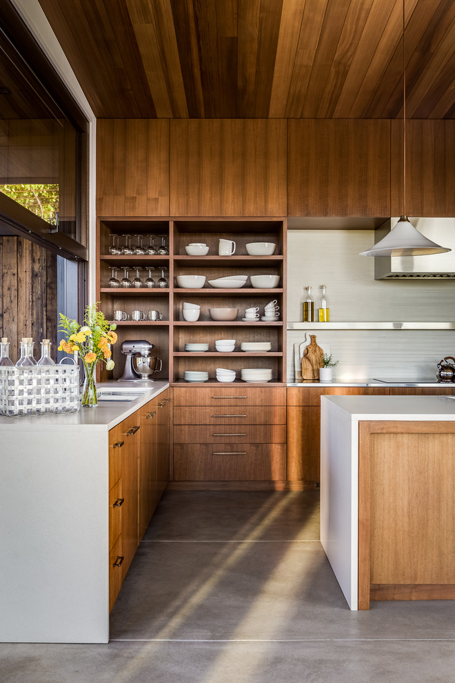 Inspiration for an asian l-shaped kitchen in San Francisco with flat-panel cabinets, dark wood cabinets, white splashback, concrete floors, with island and grey floor.