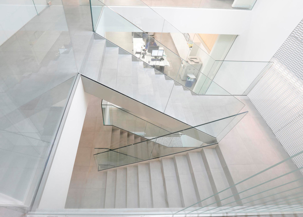 Inspiration pour un escalier carrelé urbain avec des contremarches carrelées et un garde-corps en verre.