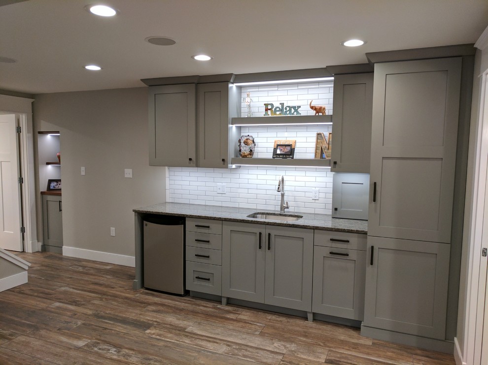 Photo of a mid-sized transitional look-out basement in Other with grey walls and porcelain floors.
