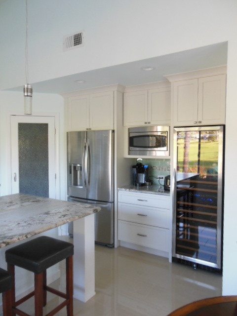 Example of a mid-sized transitional l-shaped porcelain tile and white floor eat-in kitchen design in San Diego with an undermount sink, shaker cabinets, white cabinets, quartz countertops, green backsplash, subway tile backsplash, stainless steel appliances and an island