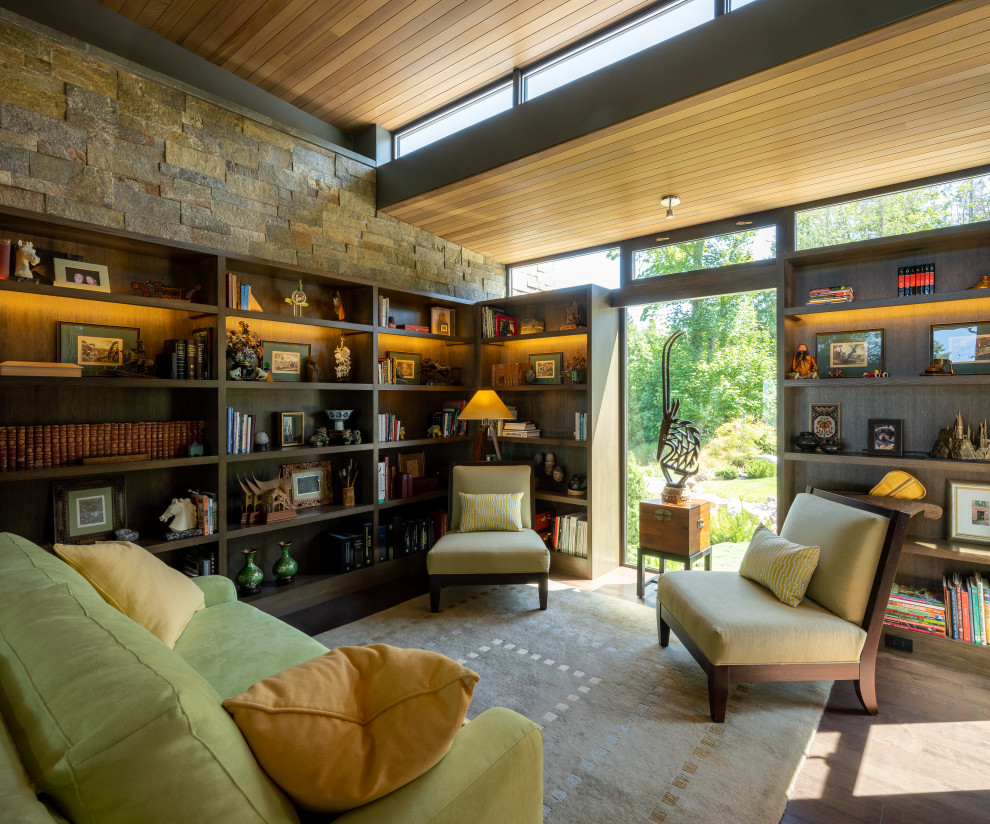 Mid-sized contemporary home office in Seattle with a library, brown walls, dark hardwood floors, a built-in desk, brown floor, wood and wood walls.