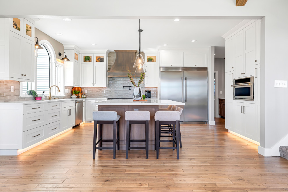 Transitional l-shaped eat-in kitchen photo with shaker cabinets, white cabinets and an island