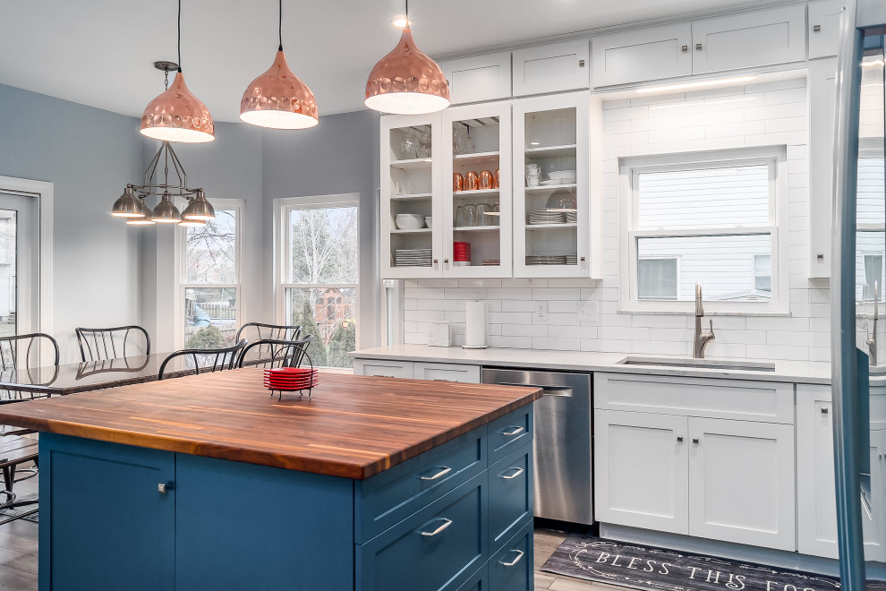 Inspiration for a mid-sized transitional l-shaped eat-in kitchen remodel in Columbus with shaker cabinets, quartz countertops, white backsplash, subway tile backsplash and an island
