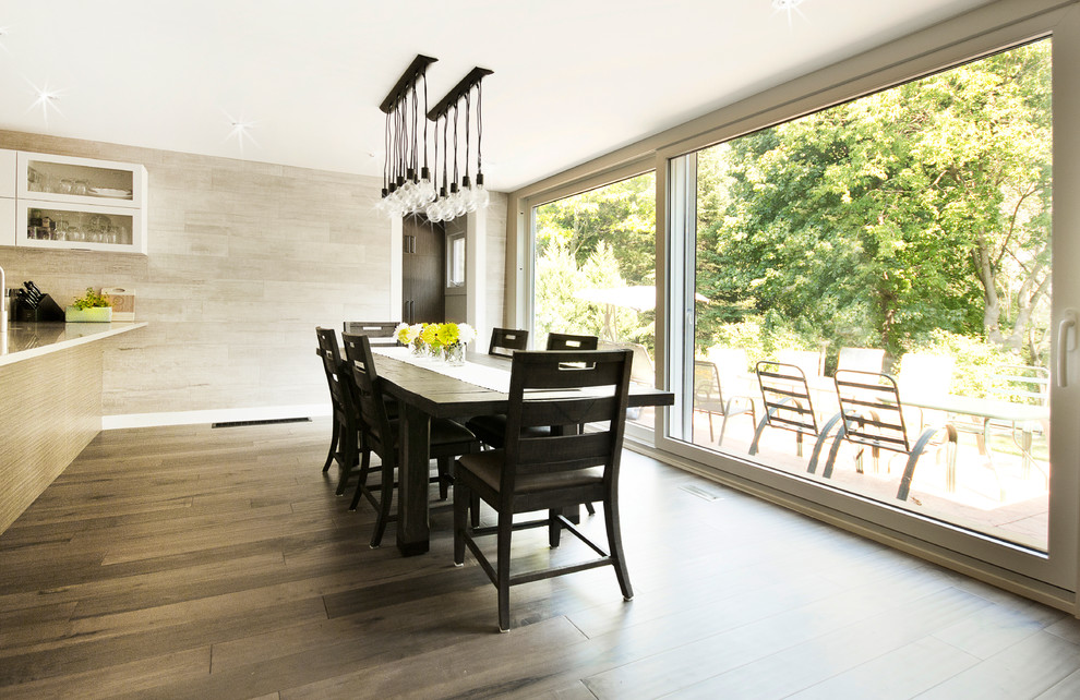 This is an example of a modern kitchen/dining combo in Toronto with beige walls and medium hardwood floors.
