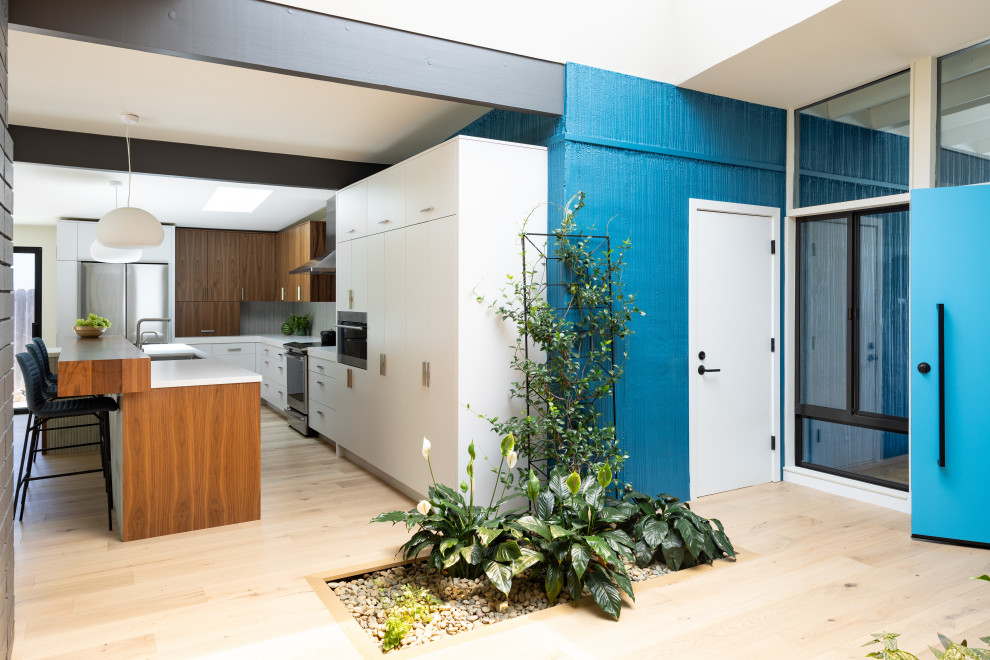 Idee per un grande ingresso moderno con pareti blu, parquet chiaro, una porta singola, una porta blu, pavimento marrone e travi a vista