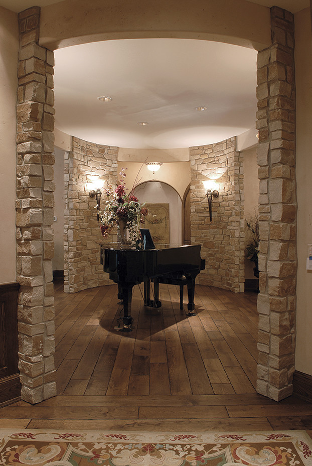 Diseño de salón con barra de bar tradicional extra grande con suelo de madera en tonos medios, todas las chimeneas, marco de chimenea de piedra, suelo marrón y vigas vistas