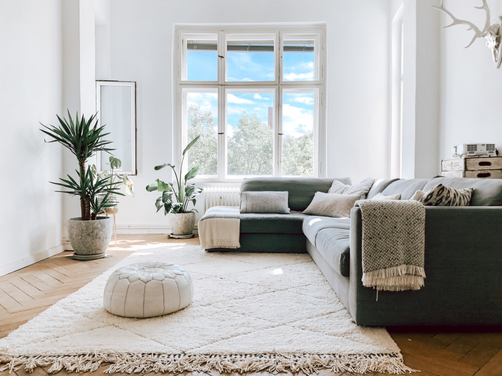 Aménagement d'une salle de séjour scandinave ouverte avec parquet clair et un sol blanc.
