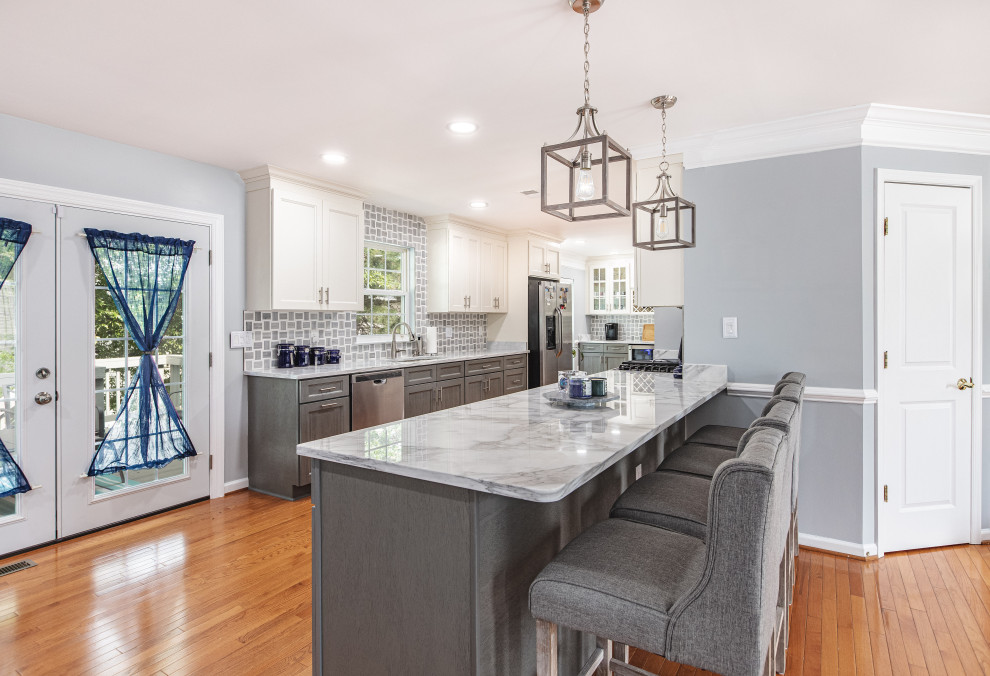 Inspiration for a large contemporary galley eat-in kitchen in DC Metro with an undermount sink, grey cabinets, marble benchtops, white splashback, marble splashback, stainless steel appliances, bamboo floors, a peninsula, yellow floor and white benchtop.