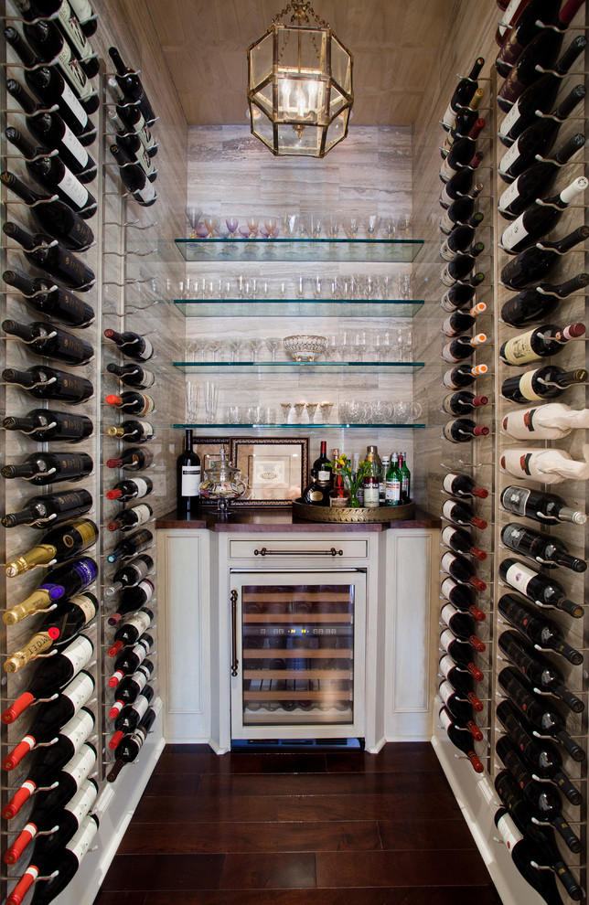 Small transitional wine cellar in Houston with dark hardwood floors and storage racks.