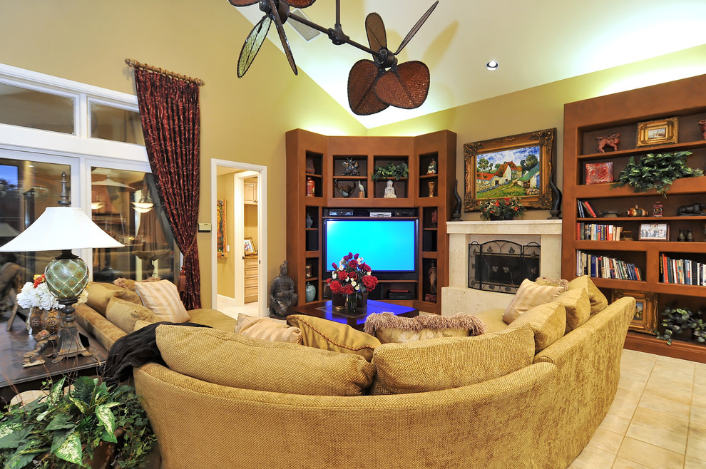 Design ideas for a tropical open concept family room in Tampa with beige walls, a standard fireplace and a corner tv.