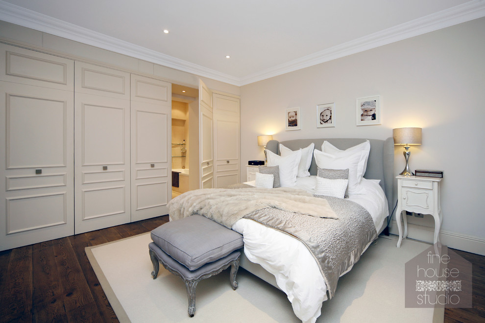 Inspiration for a large modern master bedroom in Gloucestershire with beige walls and dark hardwood floors.