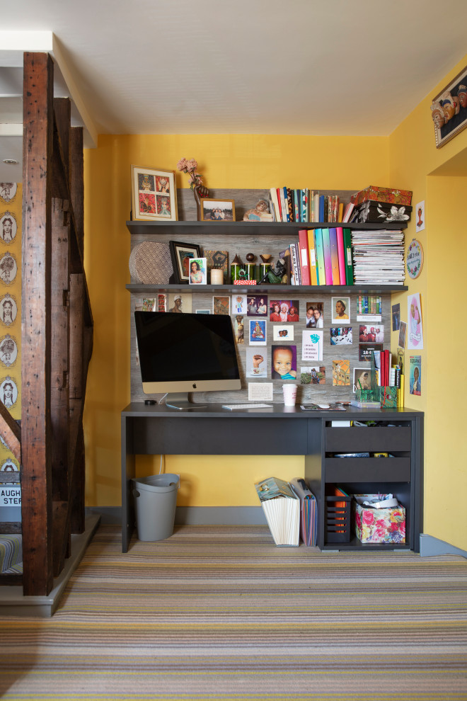 Inspiration för eklektiska hemmabibliotek, med gula väggar, heltäckningsmatta, ett fristående skrivbord och gult golv