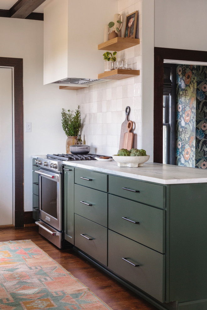 This is an example of a mid-sized galley separate kitchen with shaker cabinets, green cabinets, marble benchtops, white splashback, ceramic splashback, stainless steel appliances, dark hardwood floors, a peninsula, brown floor, white benchtop and exposed beam.