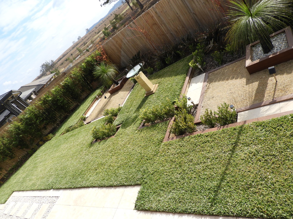 Large modern backyard partial sun formal garden in Sydney with brick pavers for spring.