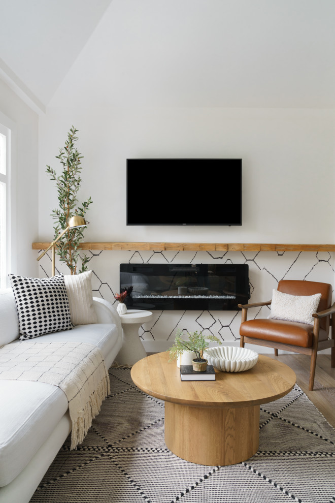Foto di un piccolo soggiorno boho chic aperto con pareti bianche, pavimento in laminato, camino sospeso, TV a parete, pavimento marrone e soffitto a volta