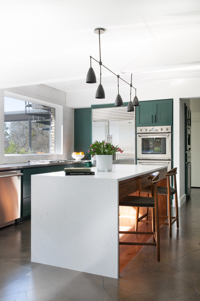 Inspiration for a large contemporary l-shaped open plan kitchen in Austin with green cabinets, white splashback, stainless steel appliances, with island, white benchtop, an integrated sink, quartzite benchtops, ceramic splashback, limestone floors, brown floor and recessed-panel cabinets.