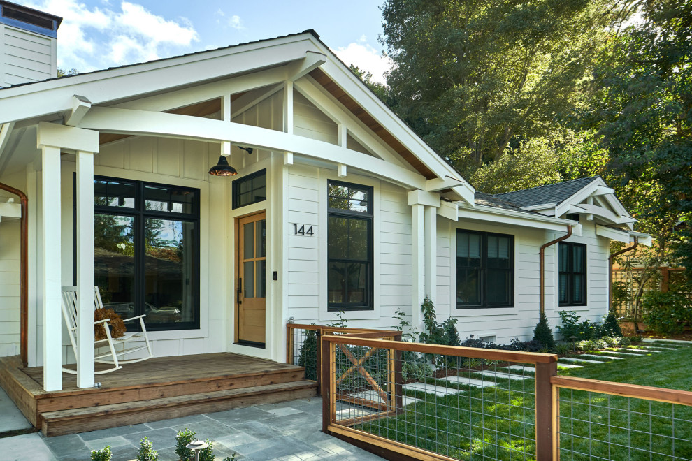This is an example of a mid-sized transitional one-storey white house exterior in San Francisco with wood siding, a gable roof, a mixed roof, a grey roof and clapboard siding.