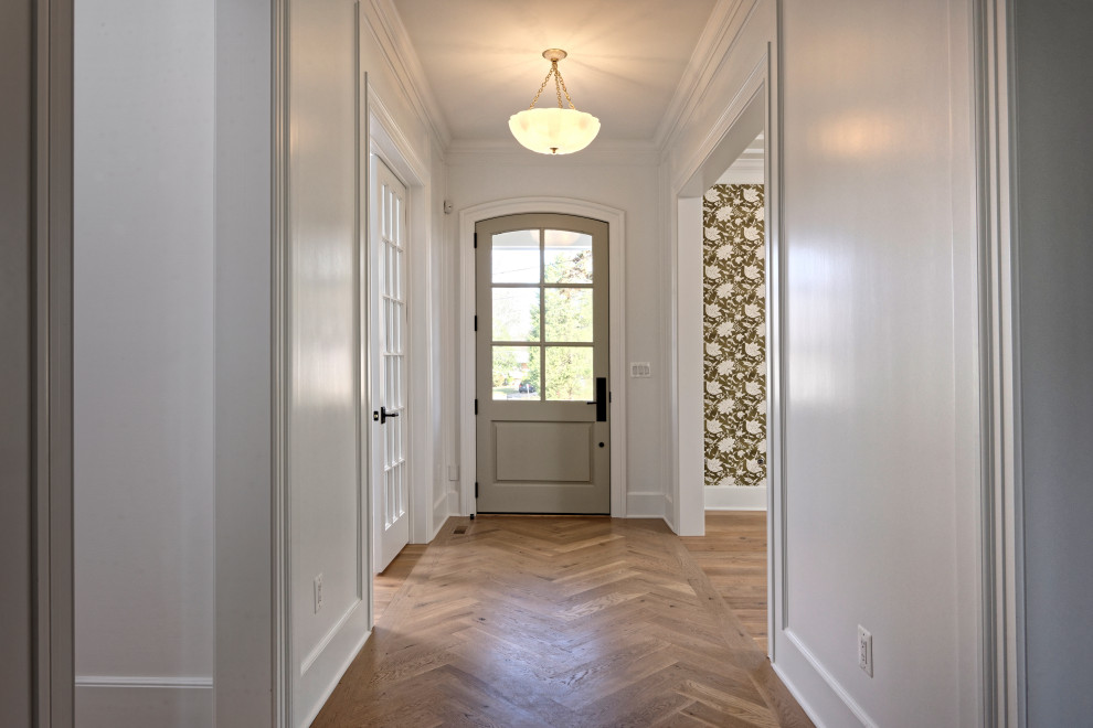 Imagen de puerta principal de estilo americano de tamaño medio con suelo de madera en tonos medios, puerta simple, puerta gris, suelo marrón y casetón