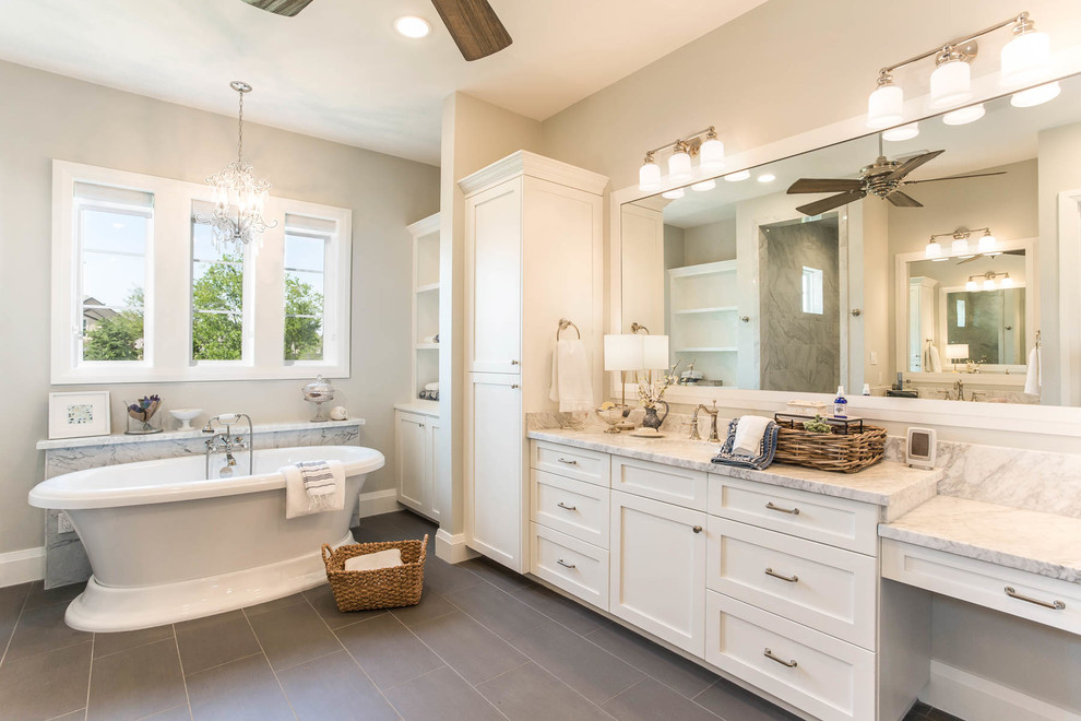 Design ideas for a country master bathroom in Houston with white cabinets, a freestanding tub, beige walls, a drop-in sink, marble benchtops and brown floor.