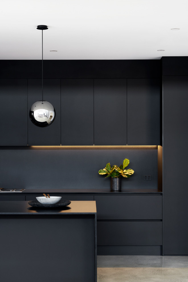 Design ideas for a large contemporary galley kitchen pantry in Sydney with flat-panel cabinets, black cabinets, quartz benchtops, black splashback, stone slab splashback, stainless steel appliances, concrete floors, no island, grey floor and black benchtop.