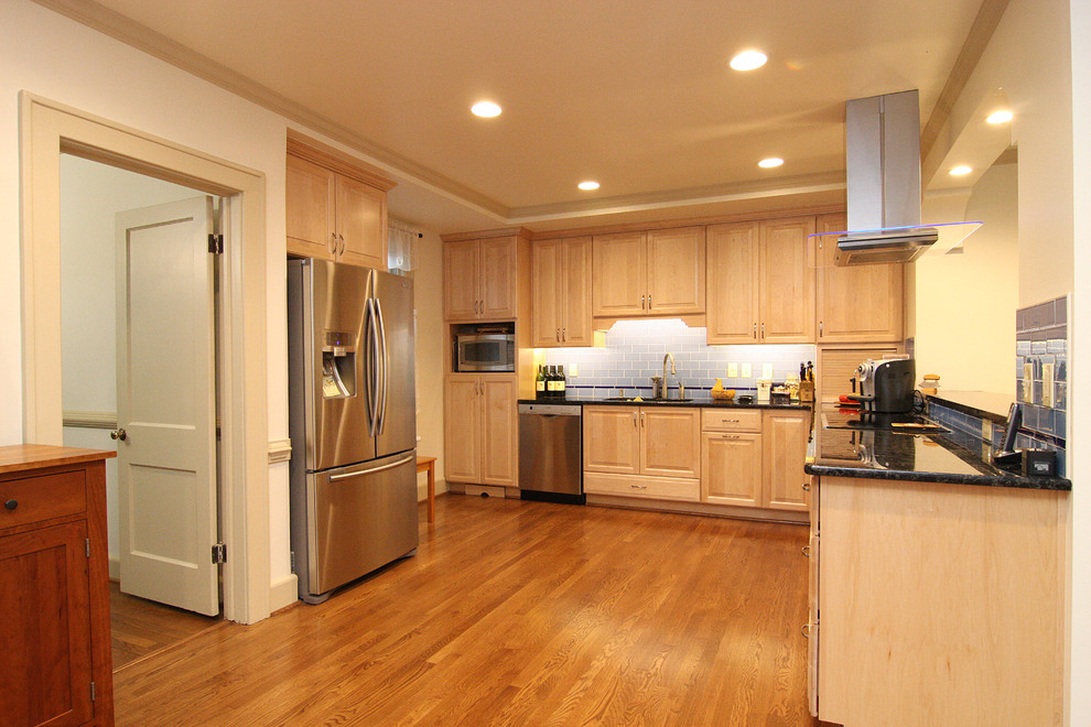 Open concept kitchen - huge transitional l-shaped medium tone wood floor open concept kitchen idea with an undermount sink, raised-panel cabinets, light wood cabinets, granite countertops, blue backsplash, glass tile backsplash and stainless steel appliances