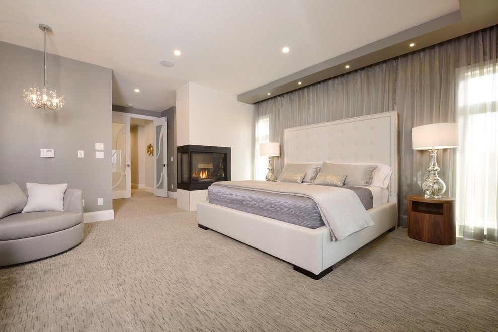 Inspiration for a large transitional master bedroom in Edmonton with grey walls, carpet, a two-sided fireplace and a plaster fireplace surround.