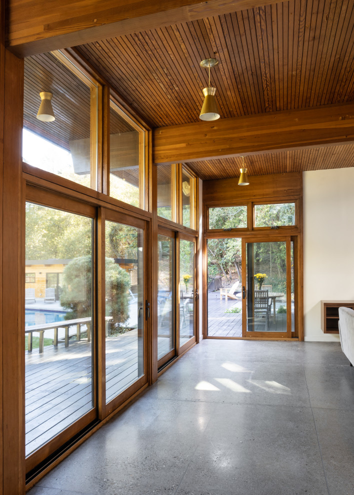 Midcentury open plan living room in San Francisco with concrete flooring and exposed beams.