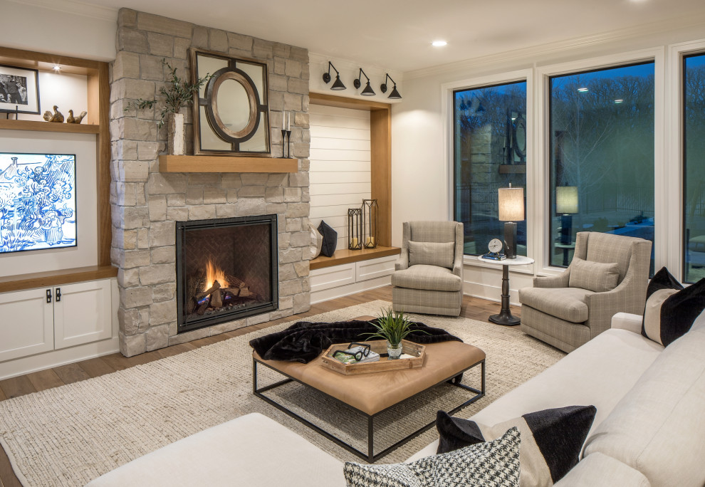 Design ideas for a mid-sized modern open concept living room in Omaha with white walls, light hardwood floors, a standard fireplace, a stone fireplace surround, brown floor and planked wall panelling.
