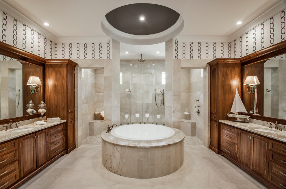 This is an example of a traditional master bathroom in Miami with recessed-panel cabinets, medium wood cabinets, a drop-in tub, a double shower, beige tile, multi-coloured walls, an undermount sink and an open shower.