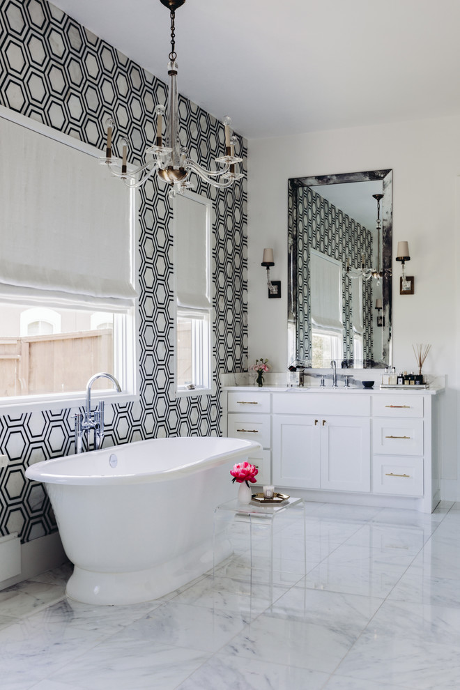 Inspiration for a transitional bathroom in Houston with shaker cabinets, white cabinets, a freestanding tub, white tile, multi-coloured walls and grey floor.