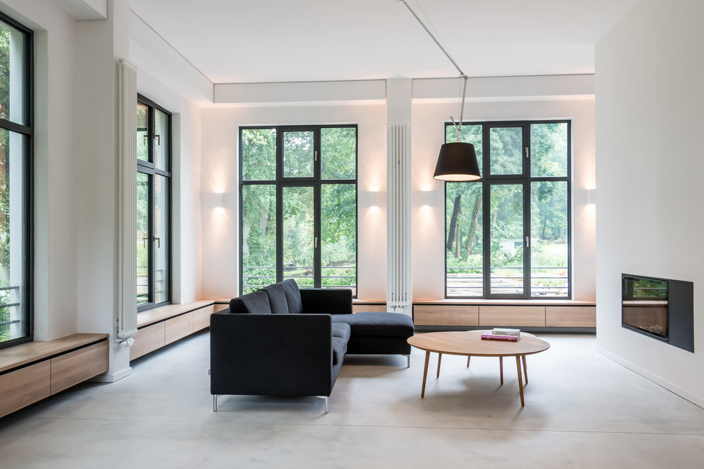 This is an example of a contemporary open concept family room in Berlin with white walls and carpet.