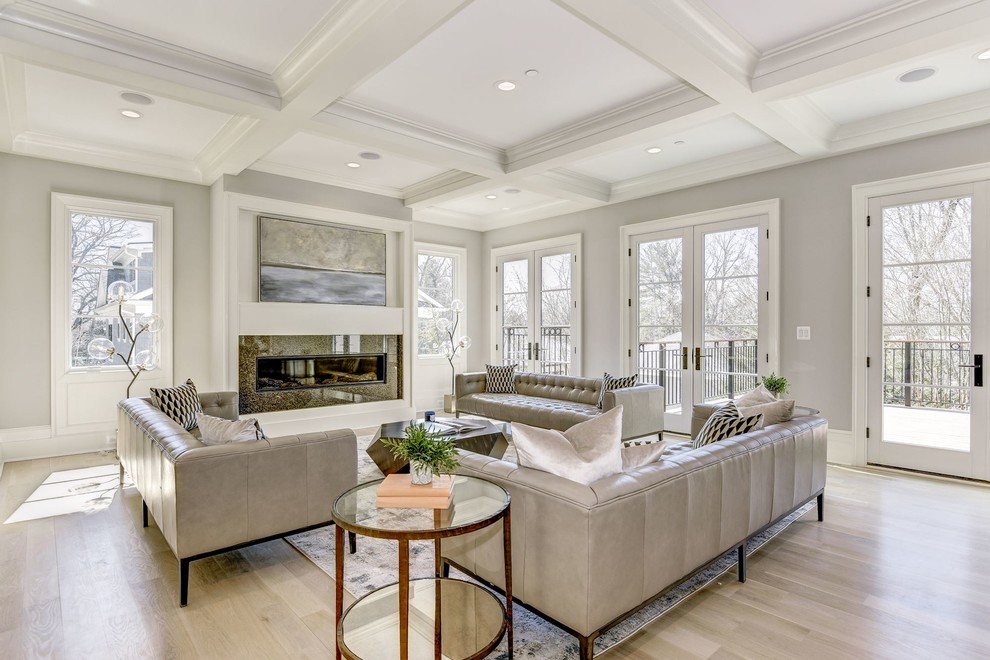 Large transitional open concept family room in DC Metro with grey walls, light hardwood floors, a ribbon fireplace, a stone fireplace surround, a wall-mounted tv and brown floor.