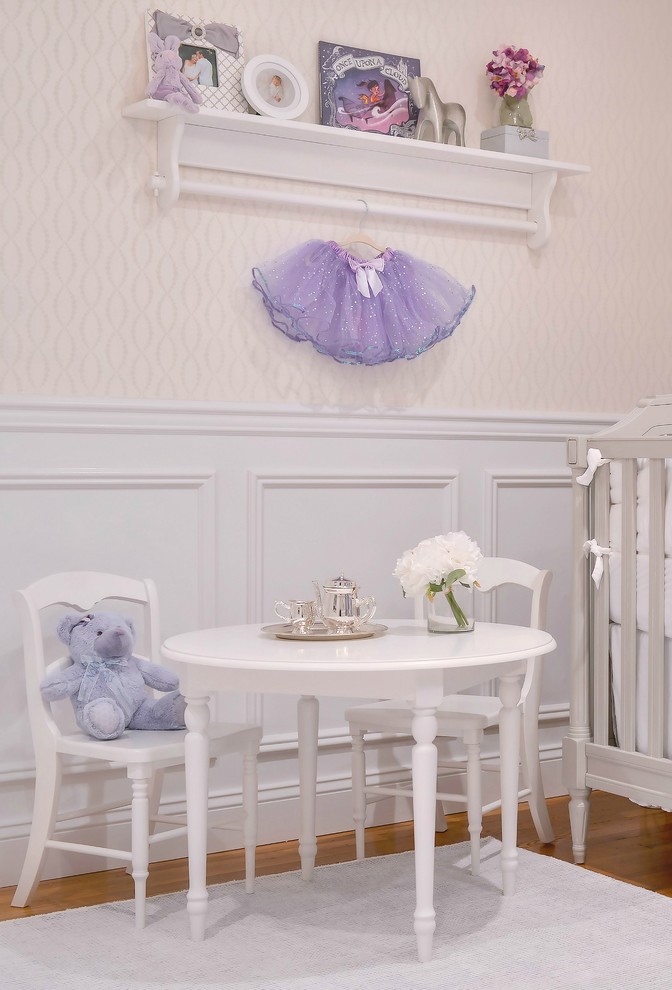 Design ideas for a mid-sized transitional nursery for girls in New York with white walls and carpet.