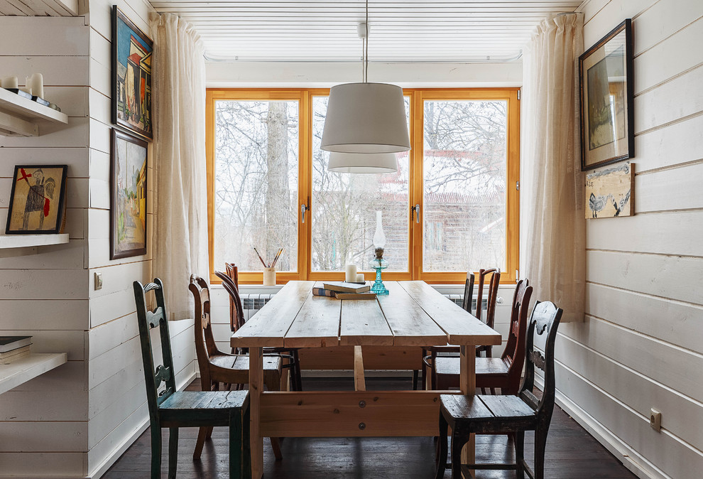 Photo of a mid-sized open plan dining in Moscow with white walls, painted wood floors, a wood stove and a metal fireplace surround.